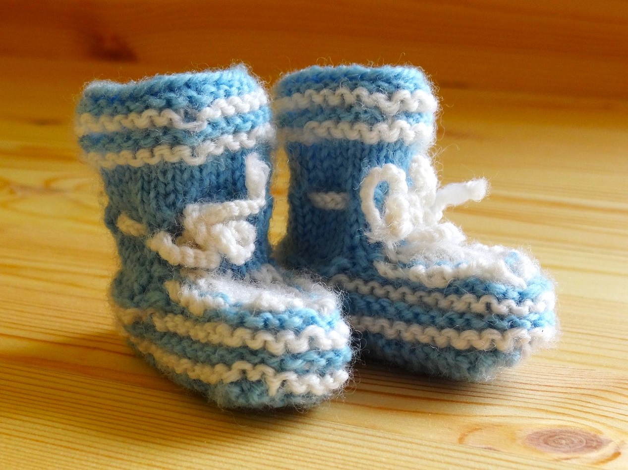 Paire de petits chaussons bleus avec noeud blanc pour bébé